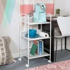 a room with a desk, chair and shelf holding various items on it in front of a colorful wall