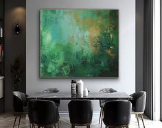 a dining room table with black chairs and a large painting on the wall above it