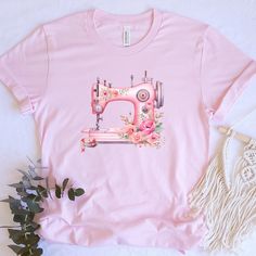 a pink t - shirt with an image of a sewing machine and flowers on it