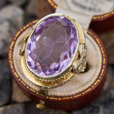 This detailed vintage amethyst ring is crafted in 14k white gold with a yellow gold plating and features a 10 carat bezel set oval cut lilac amethyst with a beautifully pierced under gallery and bow motif on each shoulder. The ring is currently fits like a size 5. The gemstone has light abrasion which is not distracting. Oval Purple Amethyst Ring With 17 Jewels, Heirloom White Gold Amethyst Ring, Formal Purple Amethyst Ring With Bezel Setting, Lavender Amethyst Ring For Formal Occasions, Heirloom Style Purple Oval Amethyst Ring, Formal Lavender Oval Amethyst Ring, Formal Lavender Oval Ring, Oval Amethyst Ring With Bezel Setting For Formal Occasions, Heirloom Style Purple Amethyst Ring With Bezel Setting