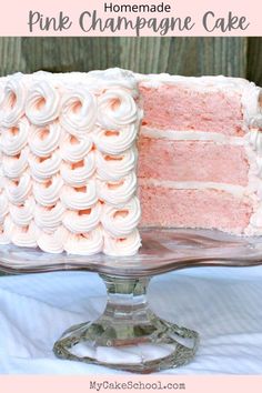 a pink cake with white frosting on a glass plate