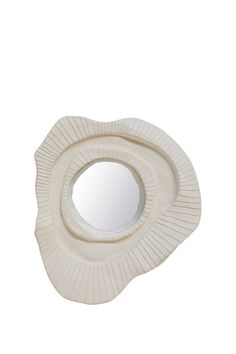 a white circular mirror sitting on top of a table