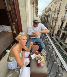 two people sitting on a balcony eating food