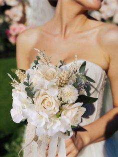 a woman holding a bouquet of flowers in her hands