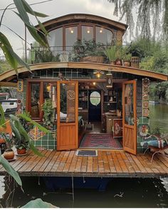 a houseboat is sitting on the water with plants growing out of it's windows