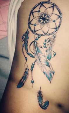 a woman's stomach with a tattoo on it that has an image of a dream catcher