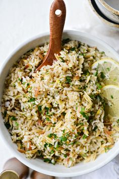 a bowl filled with rice and garnished with lemon wedges on the side