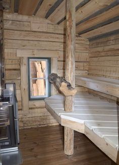 there is a small bird perched on the window sill in this log cabin with wood flooring