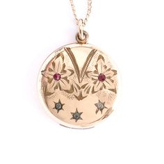 "Absolutely lovely antique locket is a beautiful rolled gold on a gold filled chain has an etched floral and star motif. Made by R.M.B. MacDonald & Company Inc. of Attleboro MA (1874 - 1922).  See all our photos. Two etched flowers with red stone centers above three starbursts set with clear stones.   The back was not monogrammed by the original owner, as many lockets from this era were.  It remains smooth and shiny with very little visible wear. Inside the locket, both original picture rings re Vintage Engraved Rose Gold Jewelry, Antique Engraved Locket Necklace With Flower Pendant, Antique Engraved Flower Pendant Locket Necklace, Vintage 14k Gold Locket Necklace With Vintage Charm, Antique Yellow Gold Locket Necklace With Charms, Antique Rose Gold Necklace With Vintage Charm, Heirloom Yellow Gold Locket Necklace With Charms, Yellow Gold Locket Necklace With Vintage Charm For Collectors, 14k Gold Locket Necklace With Vintage Charm