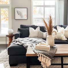 a living room filled with furniture and pillows on top of a wooden table in front of a window