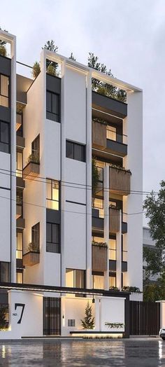 an apartment building with balconies and plants on the top floor is shown at dusk