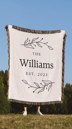 a woman standing in front of a white blanket with the words, the williamss on it