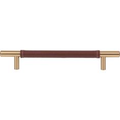 an image of a brass handle on a white wall with brown leather trimmings