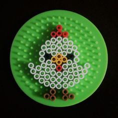 a green plate with an image of a chicken made out of circles and scissors on it