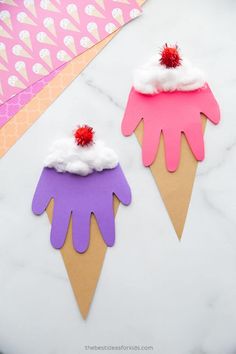 two ice cream cones with pink and purple icing on them