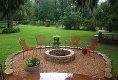 an outdoor fire pit surrounded by chairs and tables