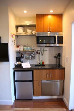 a small kitchen with stainless steel appliances and wood cabinets