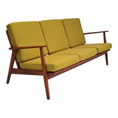 a yellow couch sitting on top of a wooden frame