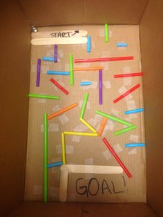 a cardboard box filled with lots of colorful sticks and writing on the inside of it