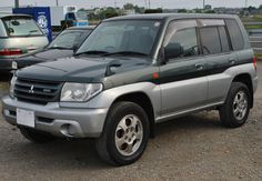 a silver suv parked in a parking lot next to other cars