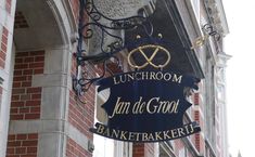 a blue sign hanging from the side of a building next to a tall brick building