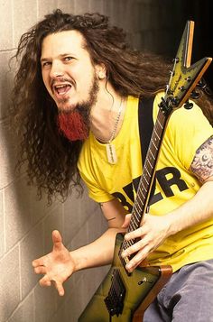 a man with long hair holding a guitar