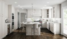 a large kitchen with white cabinets and wood flooring, along with an island in the middle