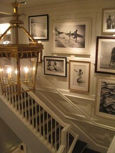 the stairs are lined with framed pictures and chandelier