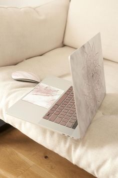 an open laptop computer sitting on top of a white couch