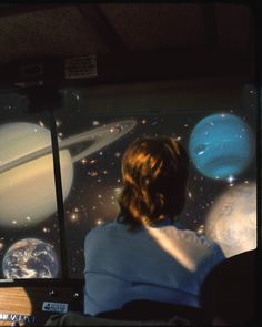 a person sitting in front of a computer screen with planets on it