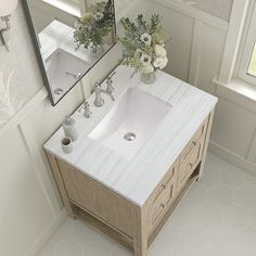 a bathroom vanity with two sinks and mirrors