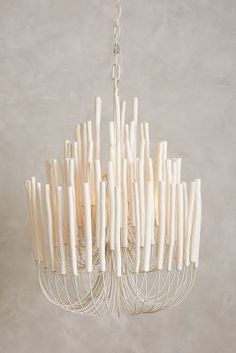 a white chandelier hanging from a chain with sticks sticking out of the bottom