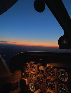 an airplane cockpit with the sun setting in the background