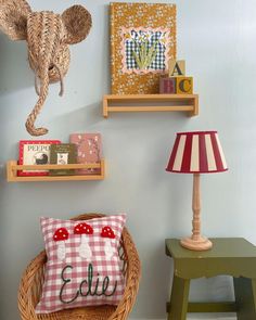 two wooden shelves with books on them and a lamp in the corner next to it