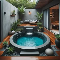 an outdoor hot tub in the middle of a wooden deck with plants and rocks around it