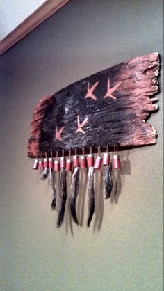 an american flag made out of wood with feathers hanging on the wall next to it