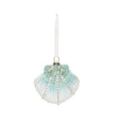 an ornament shaped like a sea shell with pearls and beads on the bottom