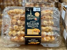 a plastic container filled with pastries on top of a table next to boxes of bread