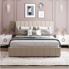 a large bed sitting next to a white dresser in a room with pink walls and pictures on the wall