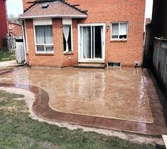 a concrete patio in front of a brick house