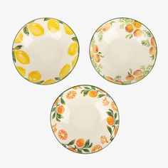 three plates with oranges and lemons painted on the sides, one is empty