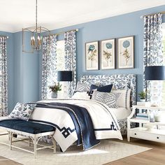 a bedroom with blue walls and white furniture