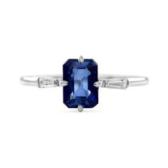 a blue sapphire and diamond ring with two baguets on the side, set in white gold