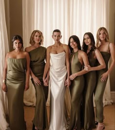 the bridesmaids are posing for a photo in their green and gold gowns