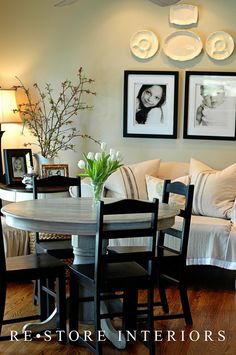 a living room filled with furniture and pictures hanging on the wall above a dining table