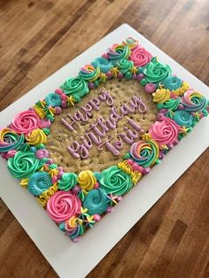 a birthday cake with colorful frosting and flowers on it