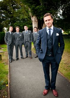 a group of men in suits standing on a path