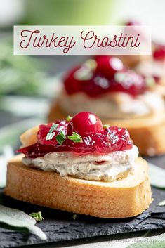 two pieces of bread with cream cheese and cherries on them sitting on a table