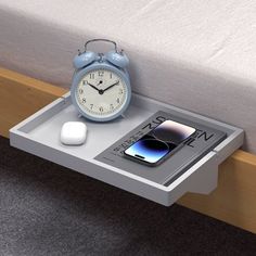 an alarm clock sitting on top of a nightstand next to a bed