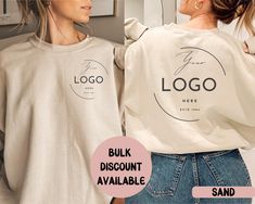 two women wearing sweatshirts with logos on them